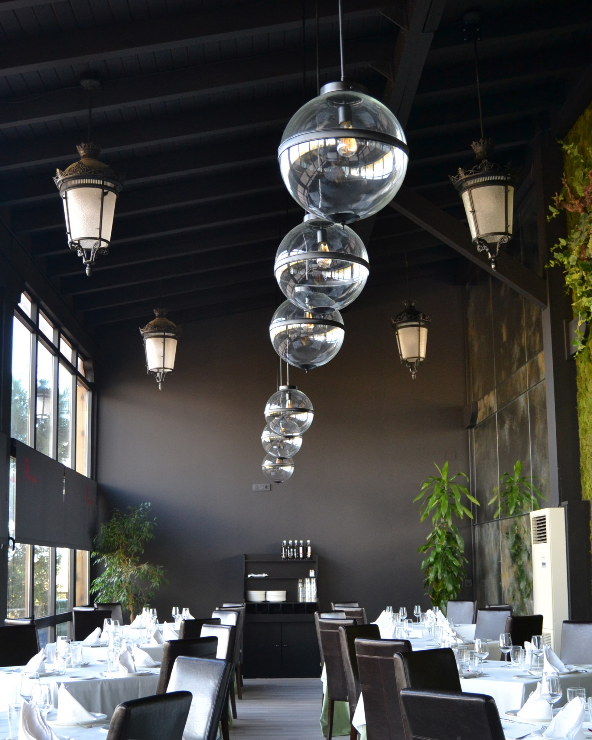 El restaurante de Finca La Estacada en tonos negros y lamparas redondas de cristal. 