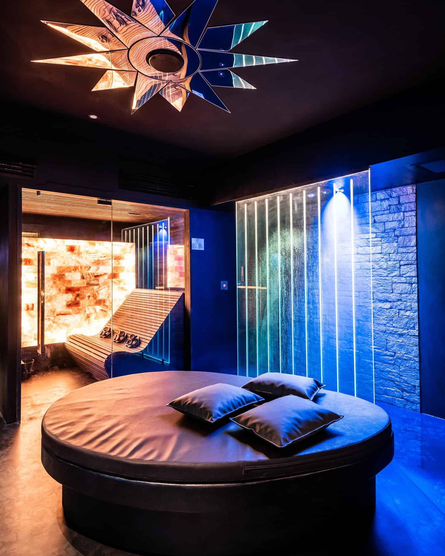 Lounge bed with moody colorful lights and a mirror stair on the ceiling in the Spa of Trilussa Palace 