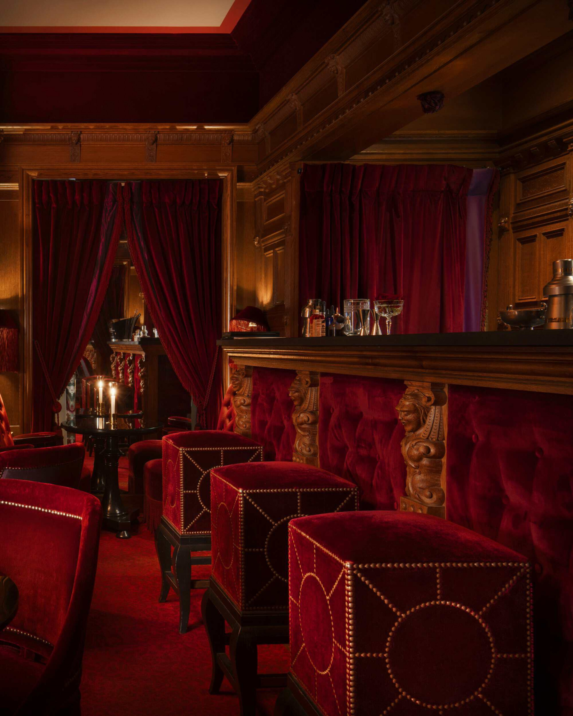 One of the salons of Maison Souquet with red velvet and mood lighting 