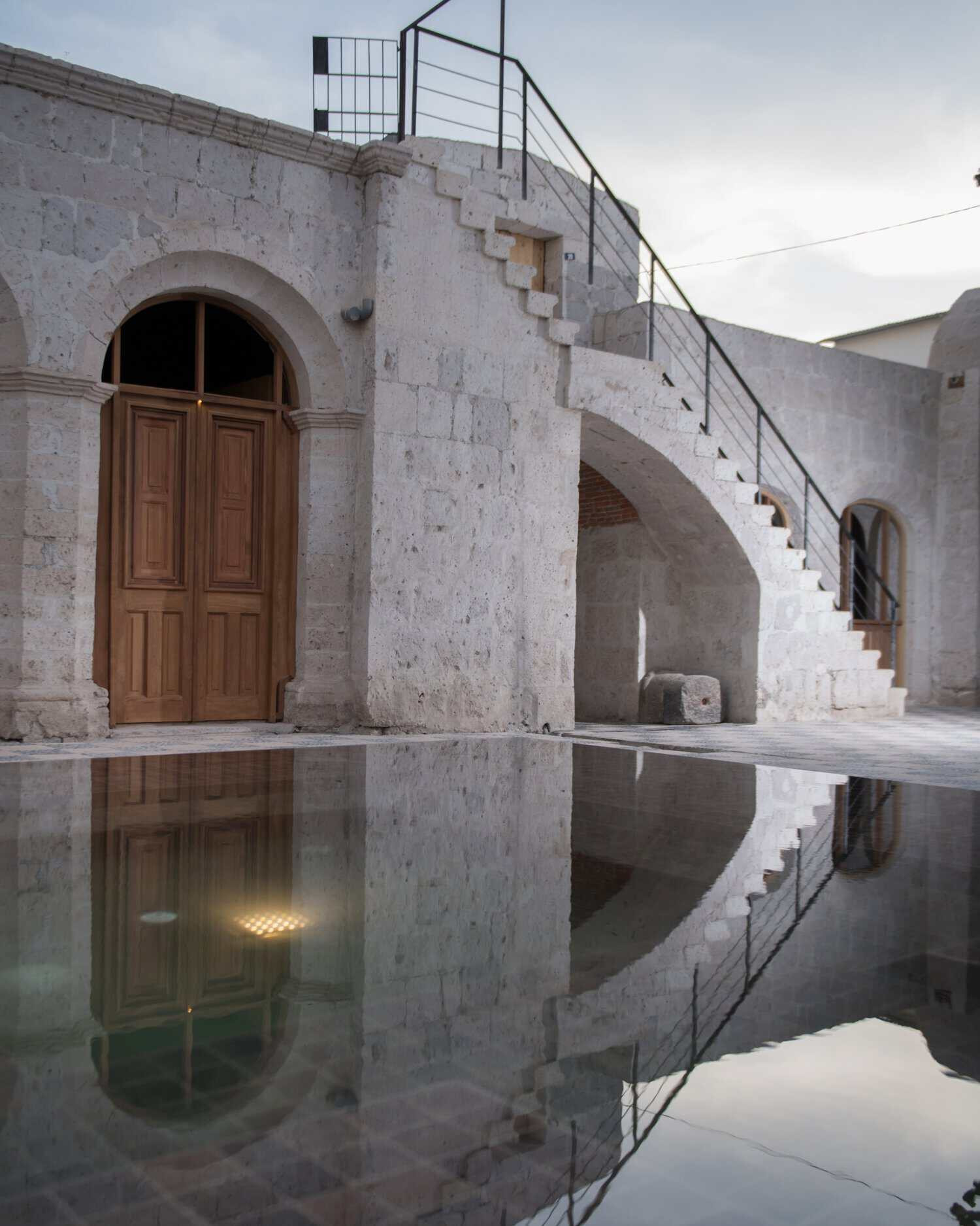 Muros históricos de sillar en Palacio Guaqui con una piscina en medio