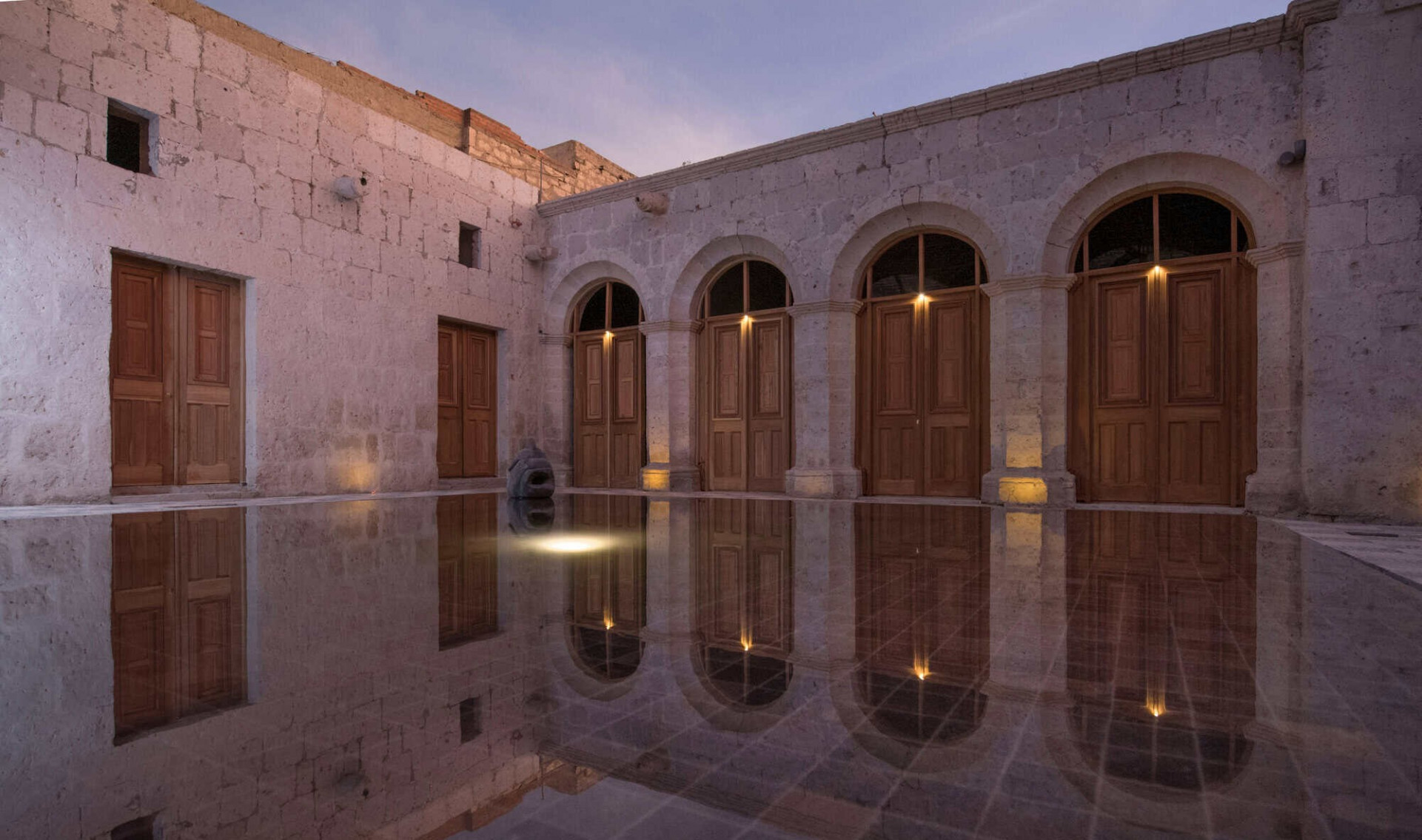 Patio interior con piscina entre paredes históricas en Palacio Guaqui en Arequipa 