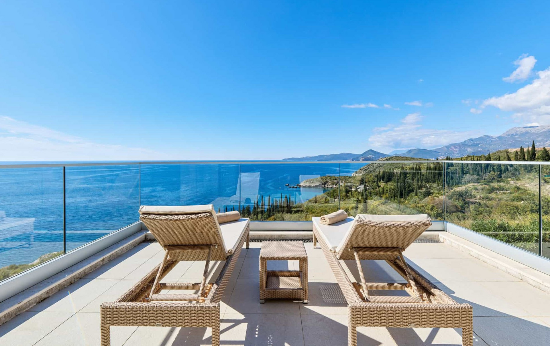 Lounge chairs overlooking a cliff with views of the Montenegro coast 