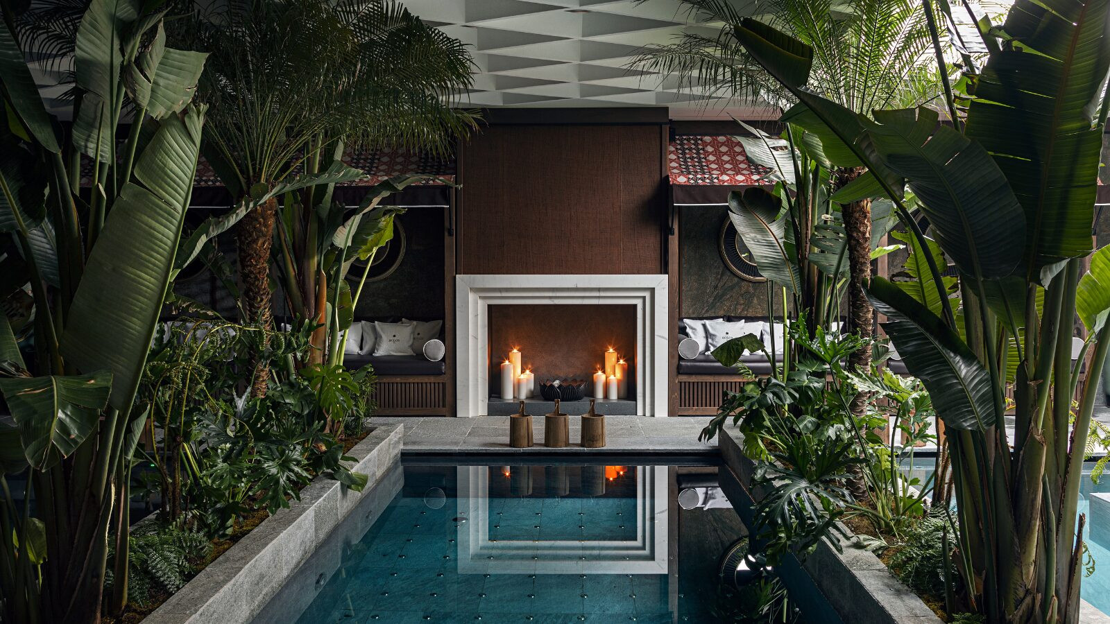 Holos Spa with serene candles an indoor pool surrounded by plants at Esplanade Boutique Hotel