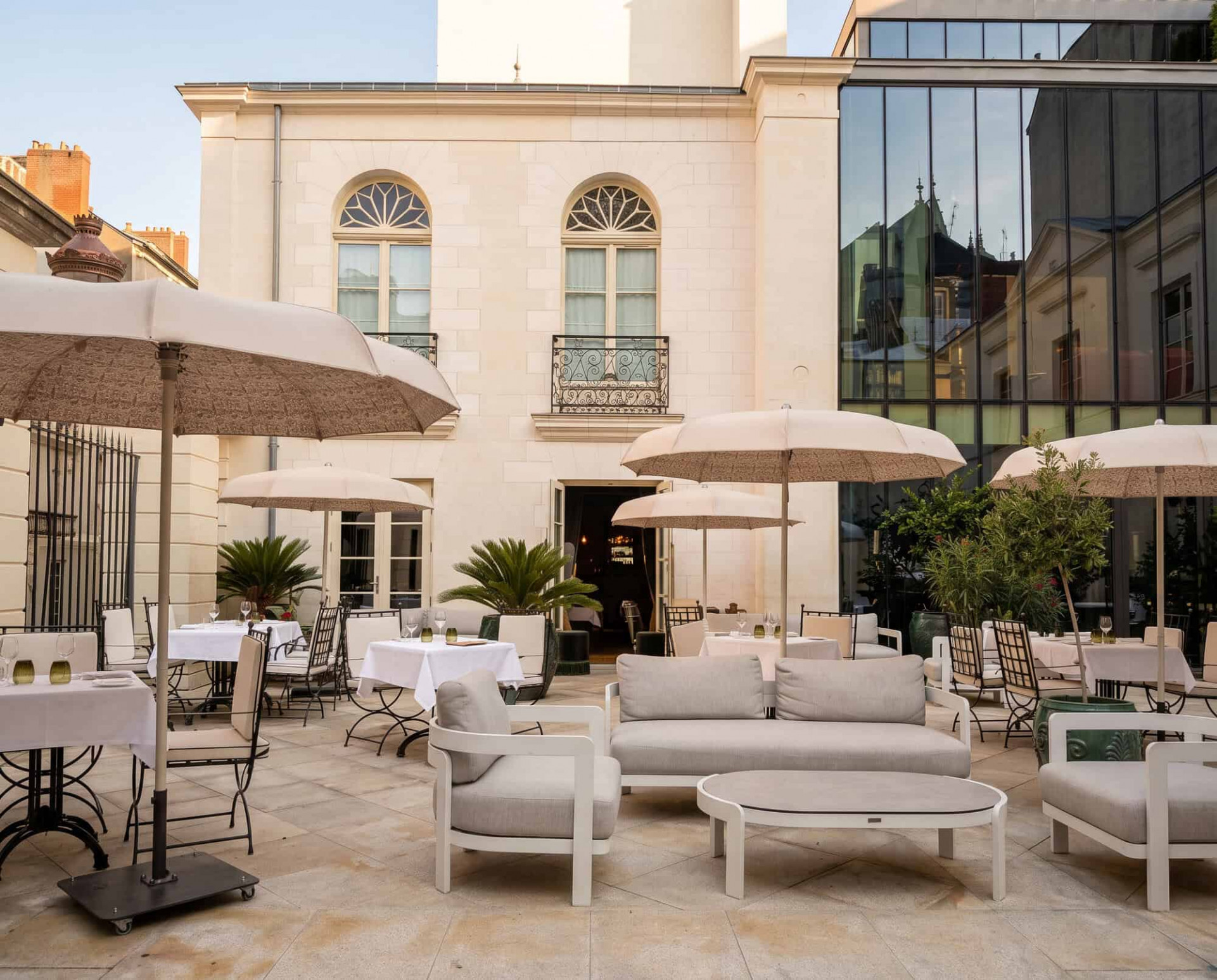Terraza elegante con sillones y sombrillas del hotel boutique Maison Maubreuil en Nantes