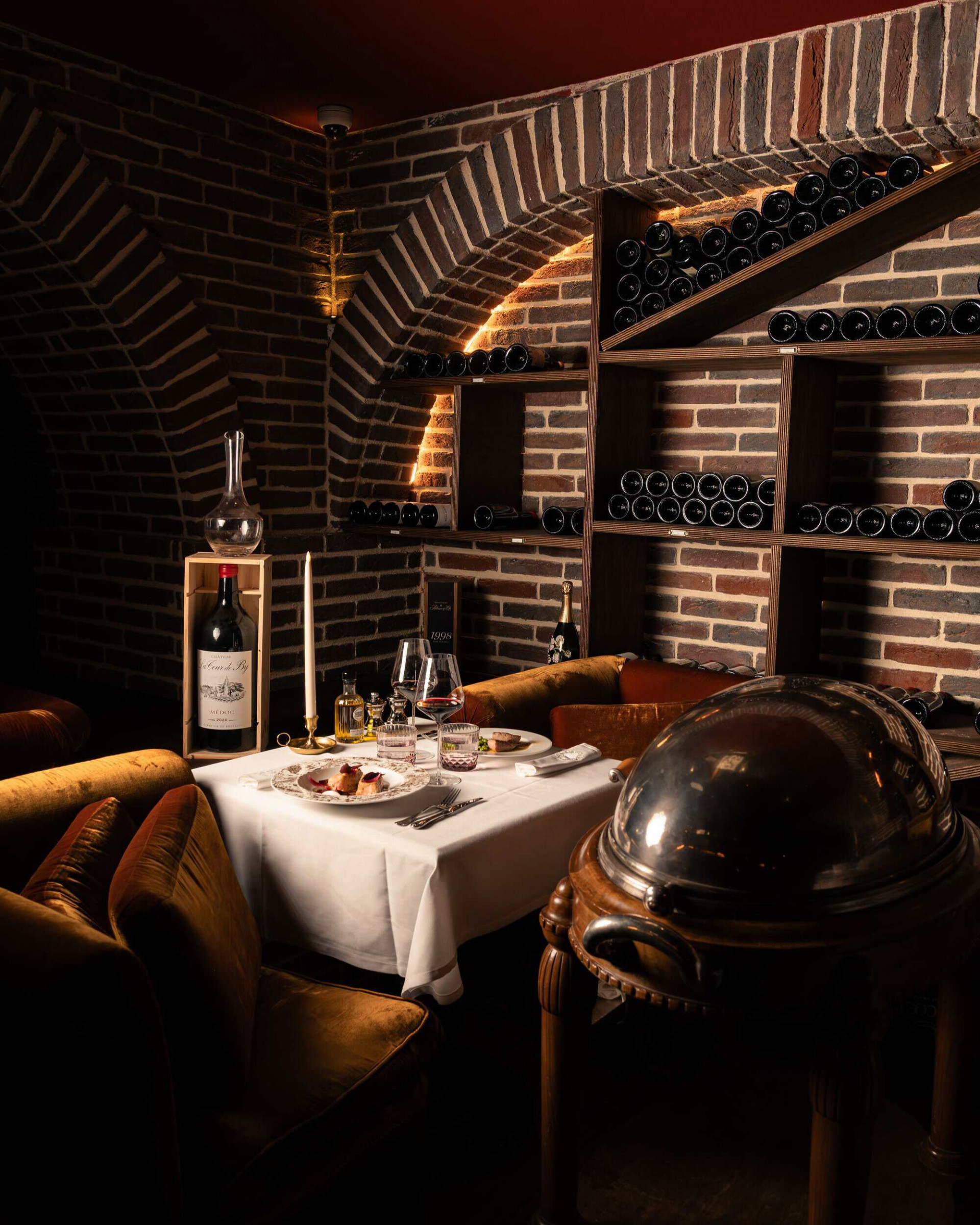 Mesa rodeada de una estanteria con vinos en la La Bodega Maubreuil