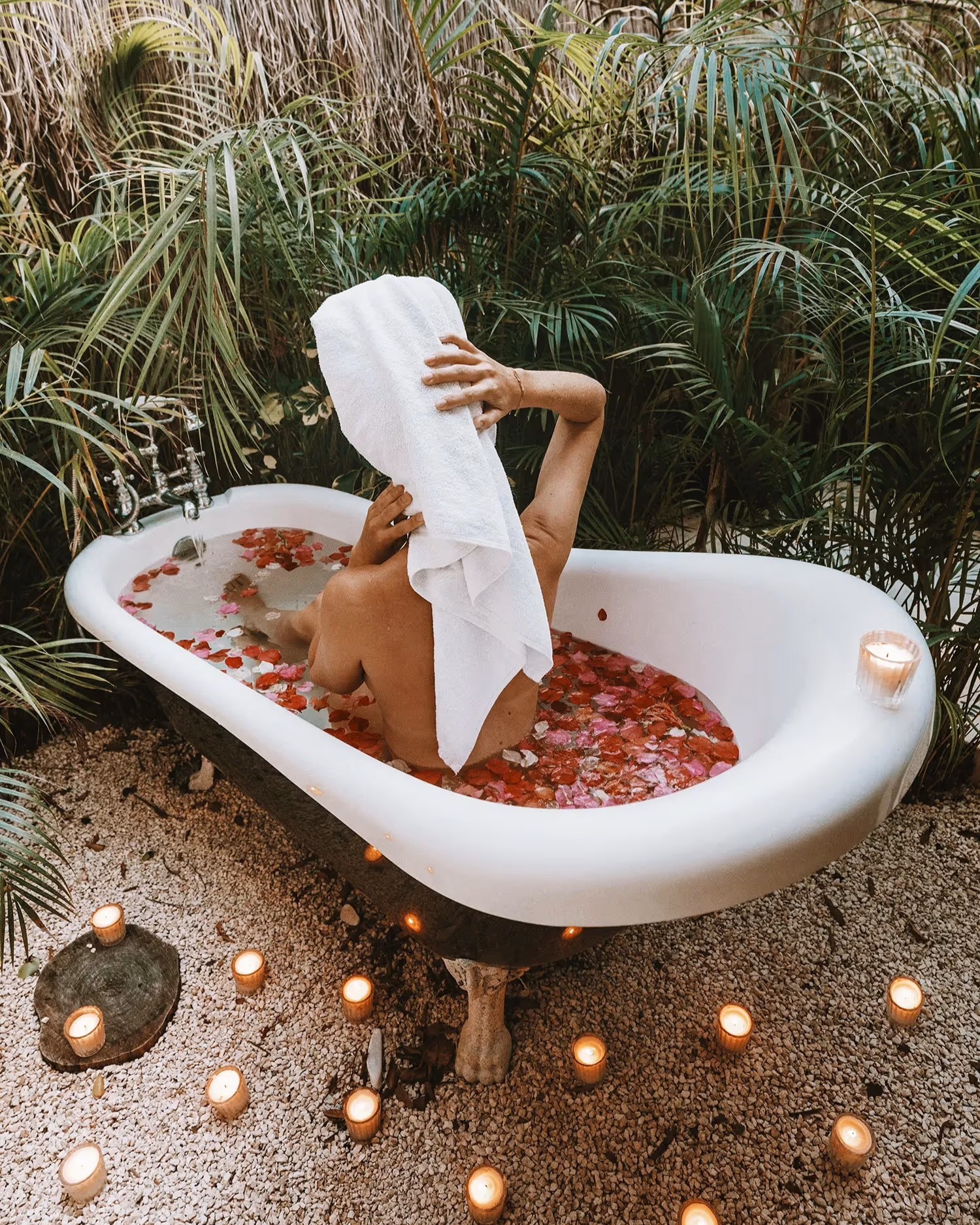 Bañera llena de flores y velas alrededor en el hotel boutique Una Vida Tulum